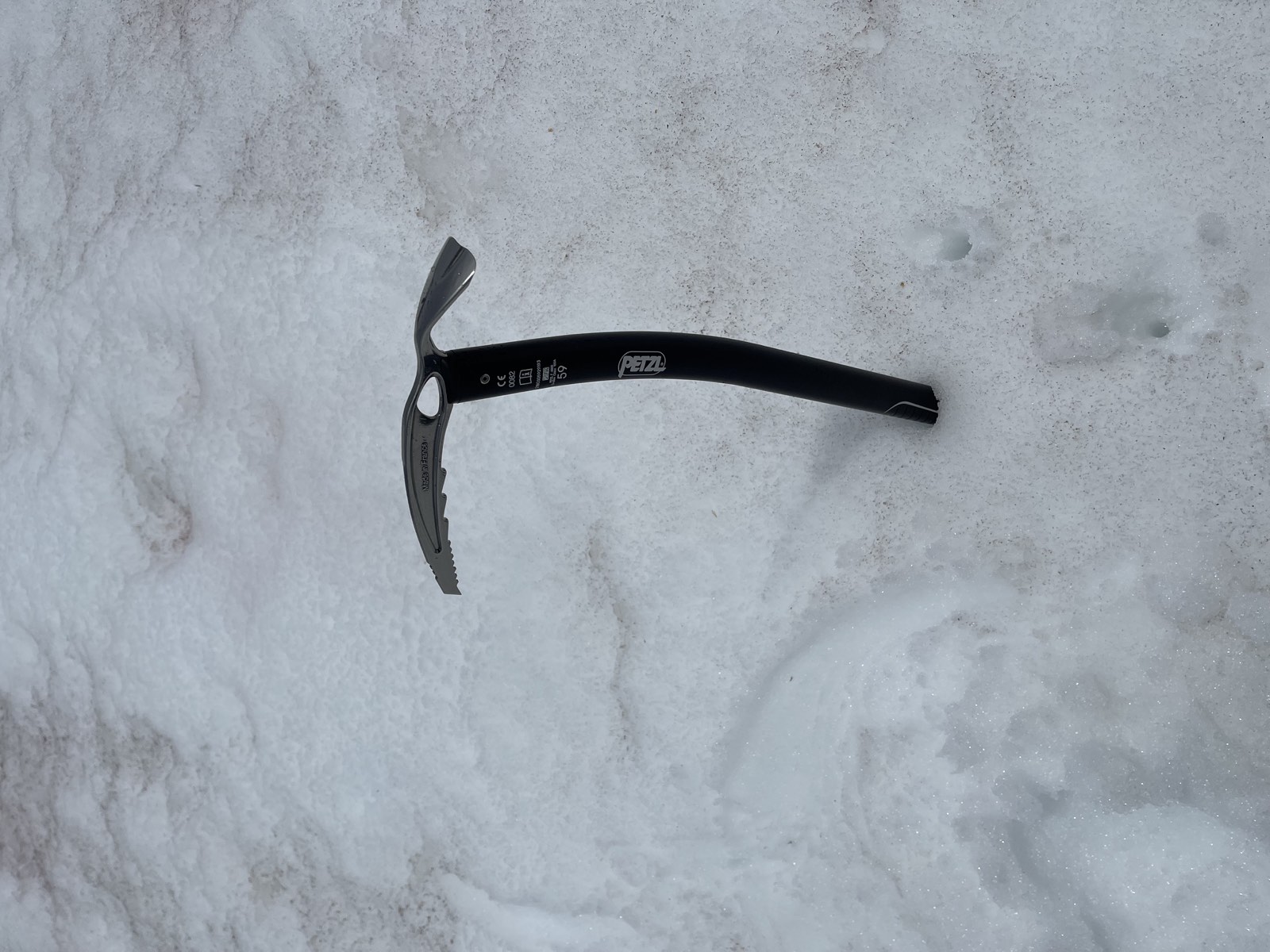 An ice axe planted in the steep snow of Lewis Glacier