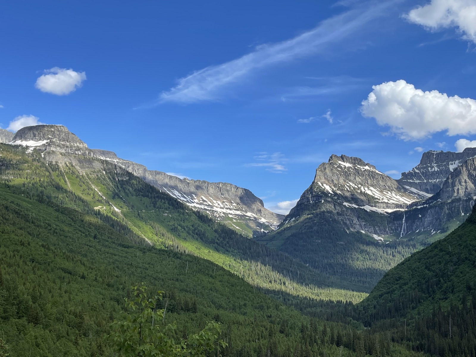 A steep rocky peak rising above the road