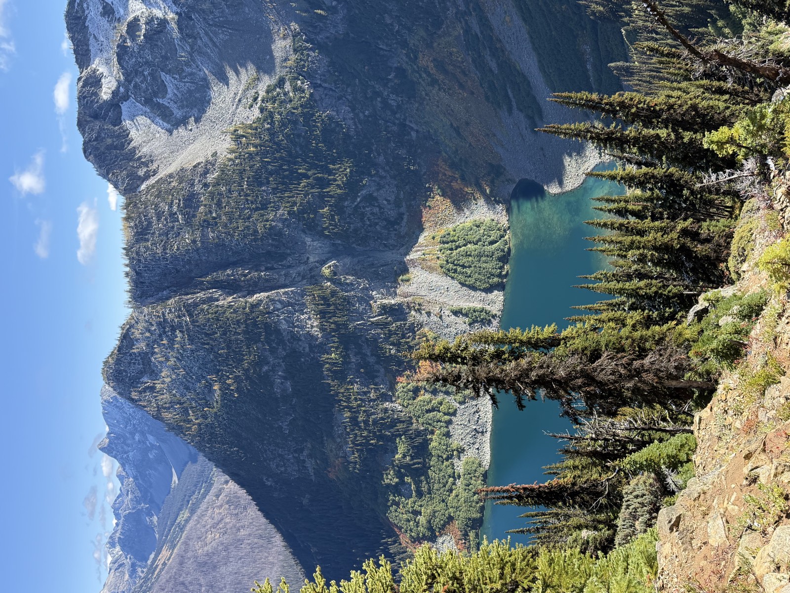 Turquoise Rainy Lake below a forested ridge and a rocky cirque