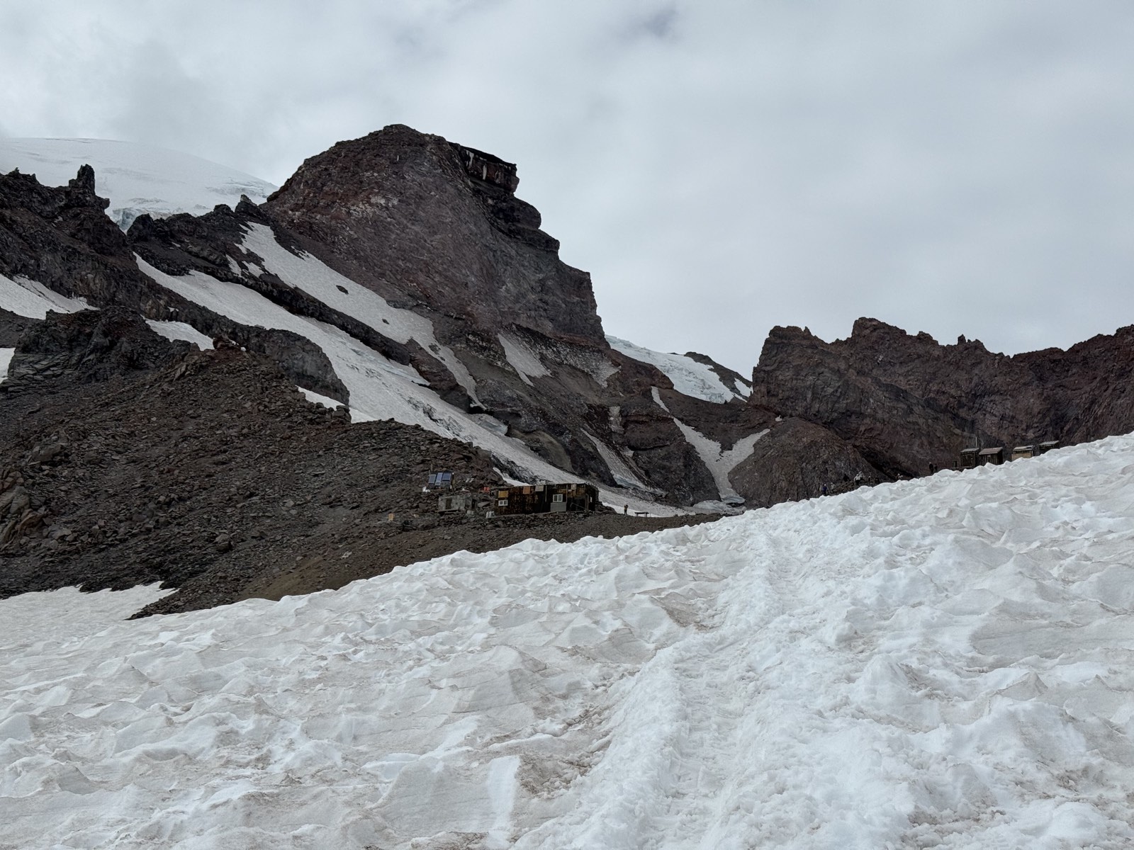 The buildings of Camp Muir still far off across the snowfield