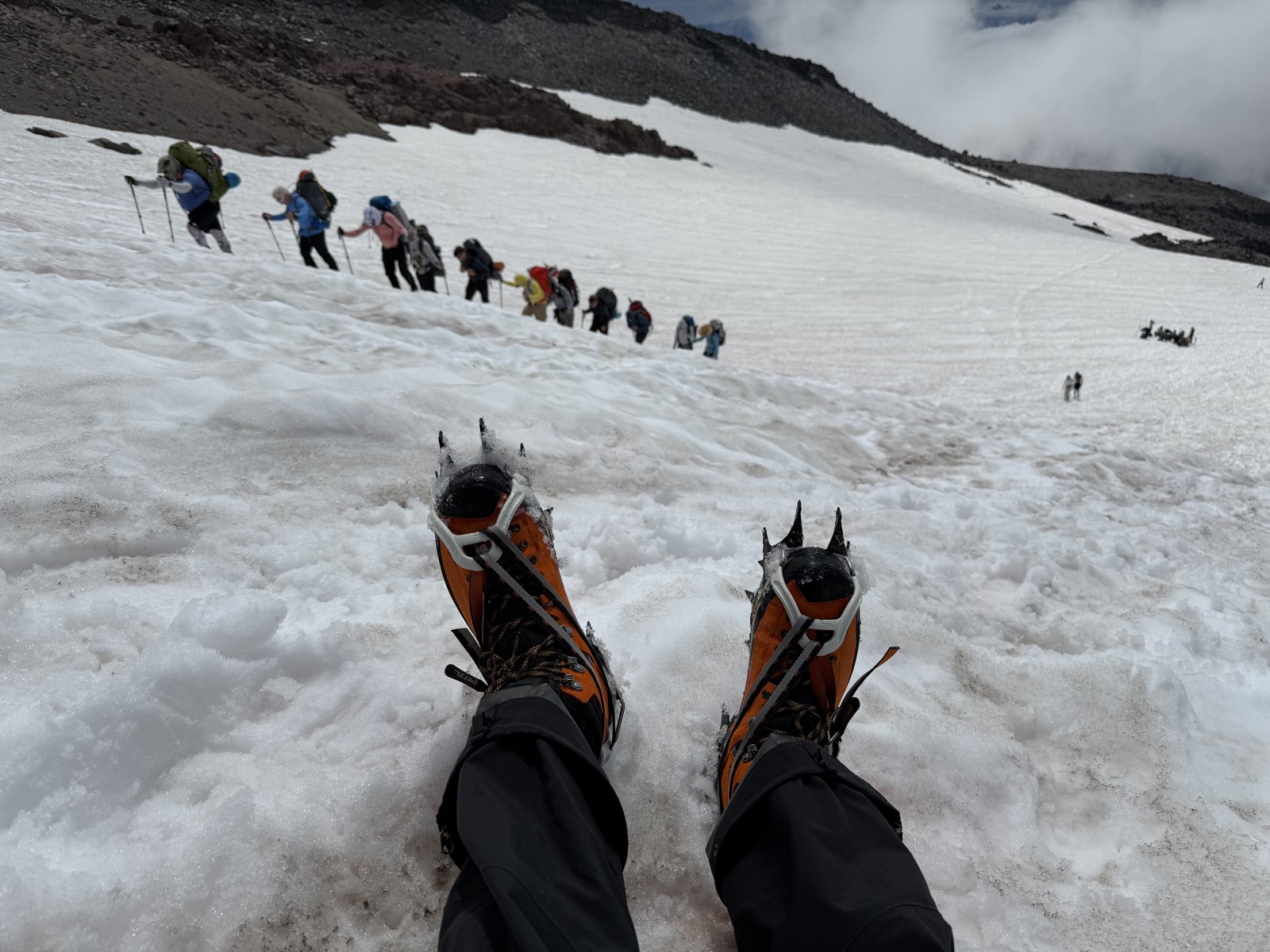 Climbers strung out single file across the snow