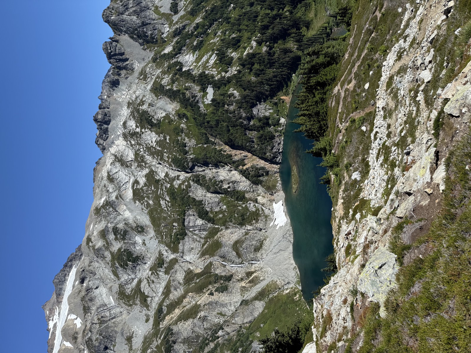 Doubtful Lake holding vivid blue-green water below the trail