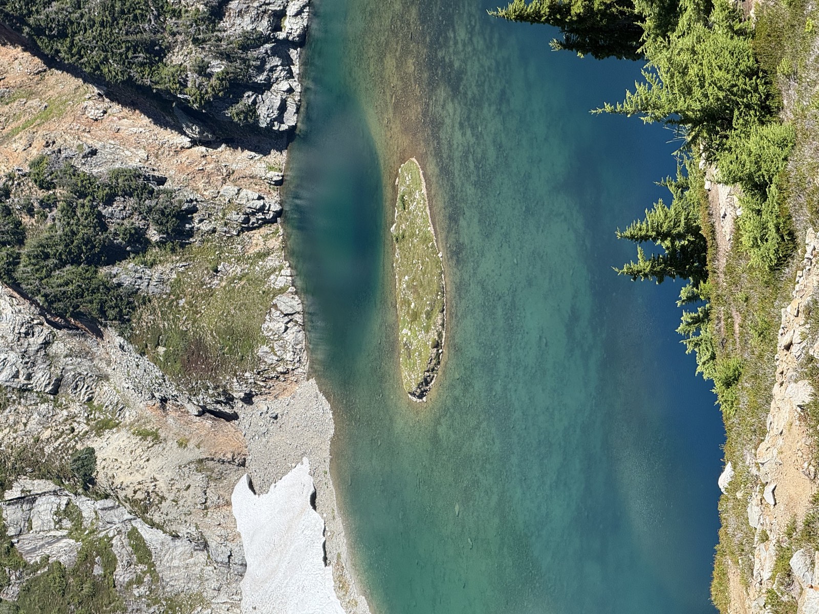 Still alpine lake water reflecting the surrounding slopes