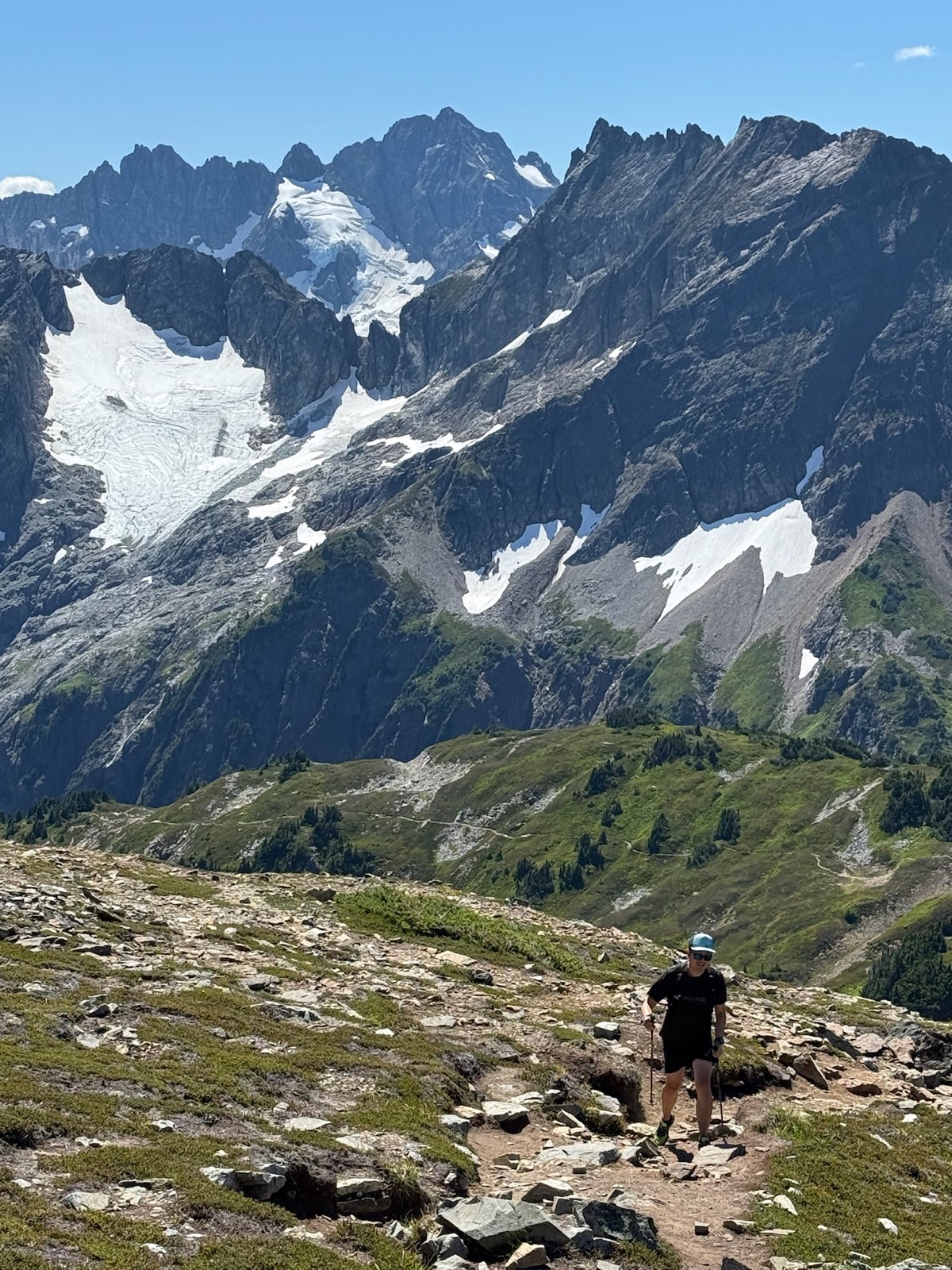 Hiker making the long climb up the open alpine slope