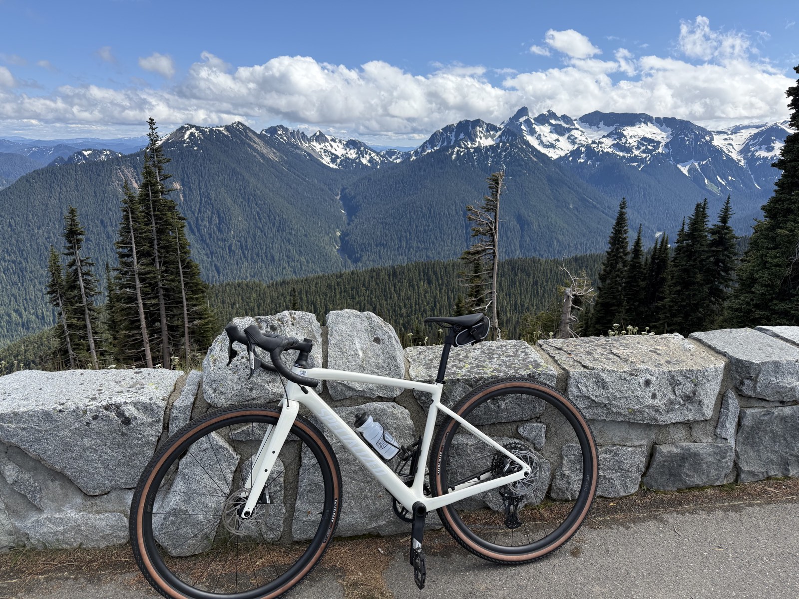 A bike parked at a viewpoint with ranks of mountains behind