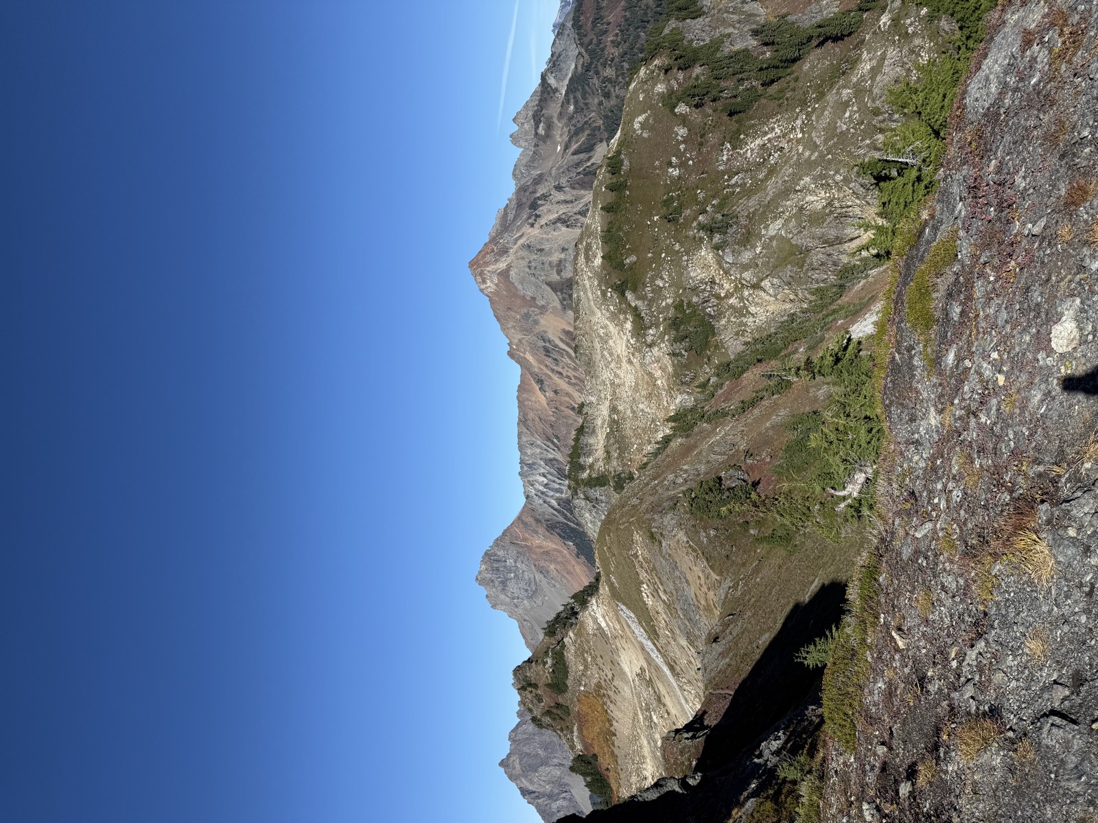 Rust-red peaks above pale slabs and green ridges